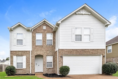 Traditional-style home featuring brick siding, concrete driveway, and a garage