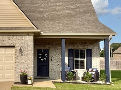View of exterior entry with an attached garage, roof with shingles, and covered porch