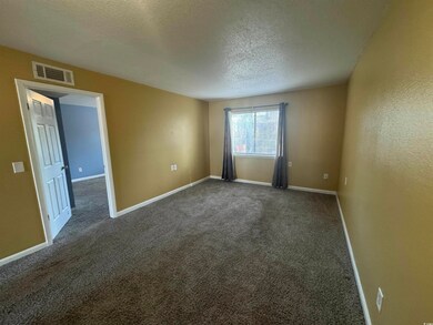 Unfurnished room featuring visible vents, dark car