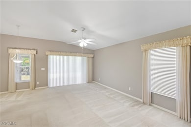 Unfurnished room with light colored carpet, vaulted ceiling, and ceiling fan
