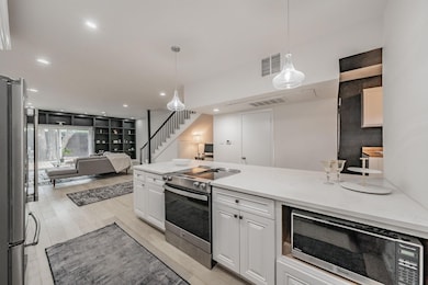 Kitchen with white cabinets, open floor plan, visi
