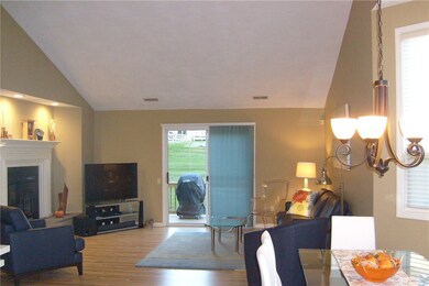 living room boasts a gas fireplace cathedral ceilings and slider to deck