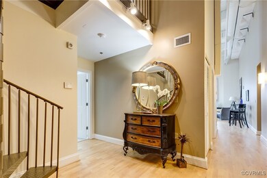 Hallway featuring a towering ceiling and light woo
