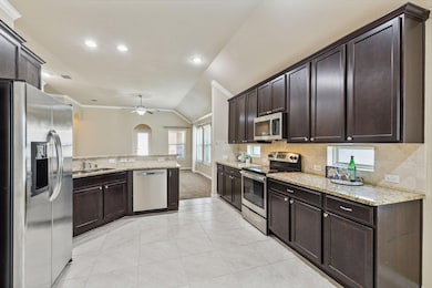 HUGE kitchen with oversized tile floors, granite countertops, pretty cabinets and open space to the living area.
