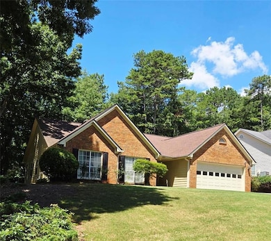 Ranch-style home with an attached garage, brick siding, and a front lawn