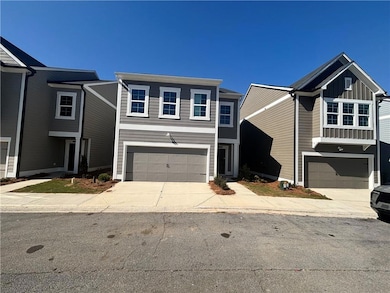 Traditional home featuring an attached garage, concrete driveway, and board and batten siding