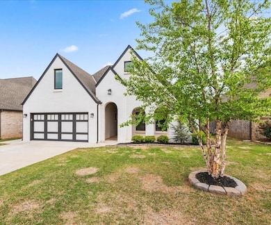 French provincial home featuring driveway, a front lawn, brick siding, and roof with shingles