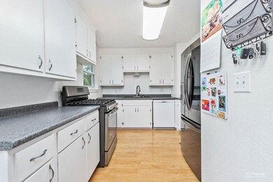 Galley kitchen with upgrades to include: new cabinetry, countertops, sink, faucet, dishwasher, microwave, flooring, lighting, double pane windows, and fresh interior paint.