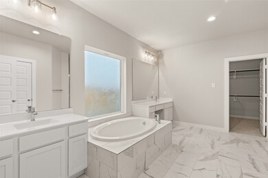 This primary bathroom is definitely move-in ready! Featuring a separate garden tub for soaking after a long day with custom tile detailing, white stained cabinets with light countertops, spacious walk-in closet with shelving, high ceilings, custom paint, sleek and dark modern finishes.
