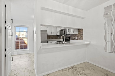Kitchen with decorative backsplash, a textured cei