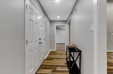 Hallway featuring baseboards, visible vents, and d
