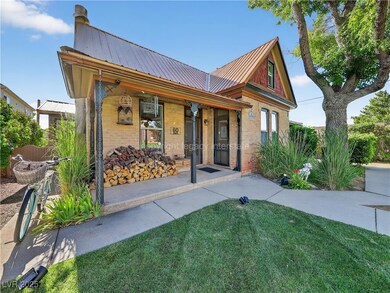 View of front of home featuring brick siding, a porch, a metal roof, and a front yard