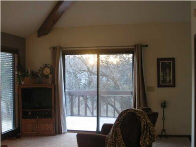 SLIDING GLASS DOORS LEAD TO LARGE DECK IN THE TREE