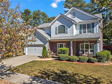 Traditional-style home with driveway, roof with sh