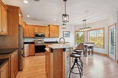 Stylish quartz center island with granite tops on back cabinetry