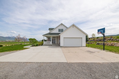 Traditional-style house featuring covered porch, driveway, a front lawn, a mountain view, and a garage