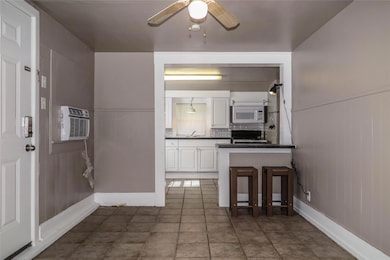 Kitchen with white microwave, dark countertops, c