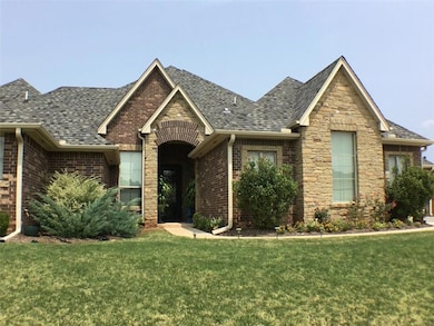 View of front facade featuring a front yard, brick siding, and a shingled roof