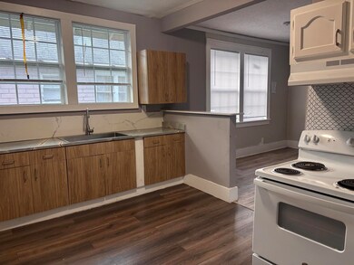 Kitchen with electric stove, dark wood finished floors, extractor fan, and plenty of natural light