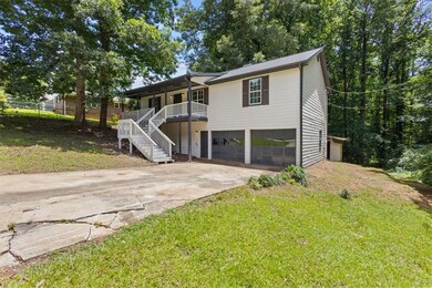 View of front of property with an attached garage, driveway, stairs, a front yard, and covered porch