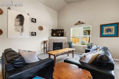 Living room with carpet flooring, a tiled fireplac