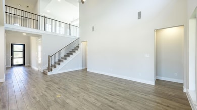Unfurnished living room with a towering ceiling, 