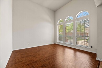 Spare room with high vaulted ceiling and dark hard