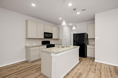 Kitchen with black appliances, light wood-type fl