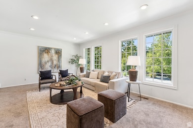Living area with crown molding, carpet flooring, and recessed lighting