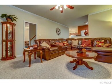 Family room with crown moulding and ceiling fan.