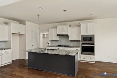 Kitchen with backsplash, stainless steel appliances, white cabinetry, and recessed lighting