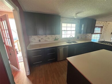 Kitchen with a sink, light countertops, dark wood