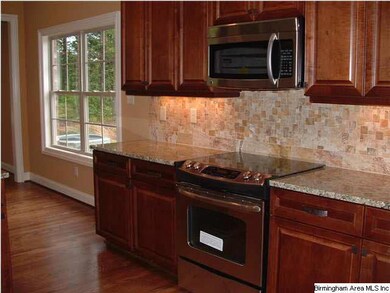 The kitchen features hardwood floors, stainless st