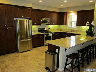 Spacious kitchen with beautiful dark cabinets, cer