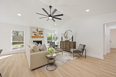 Living room with recessed lighting, vaulted ceiling, a fireplace, light wood-style flooring, and ceiling fan