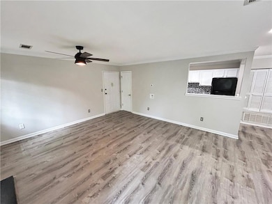 Unfurnished living room featuring light wood-style flooring, ceiling fan, and crown molding
