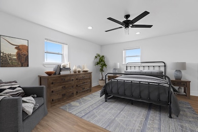 Bedroom with multiple windows, wood finished floo