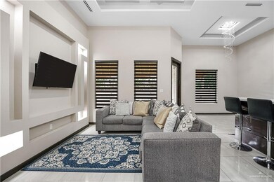 Living room with a raised ceiling and a chandelier