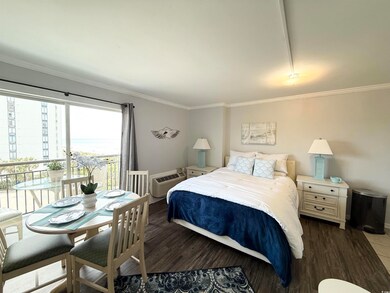 Bedroom with crown molding, a wall unit AC, and wo