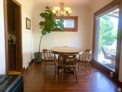 Dining room with a chandelier and dark wood-type flooring
