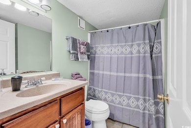 Bathroom featuring a textured ceiling, toilet, van
