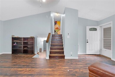 Foyer with baseboards, stairway, wood finished flo