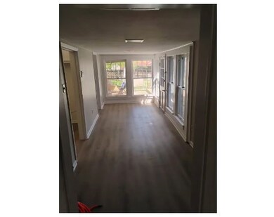 Corridor featuring dark wood-style flooring and baseboards