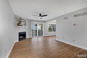 Unfurnished living room featuring wood finished floors, a fireplace, and ceiling fan