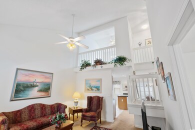 Living room with light colored carpet and a high c
