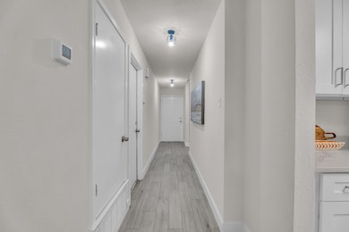 Hall featuring light wood-style flooring and base