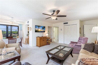Living room featuring light carpet, a textured cei
