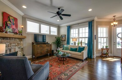 Natural light floods in and enhances the soaring ceilings topped with crown moulding and highlights the polished hardwoods. 