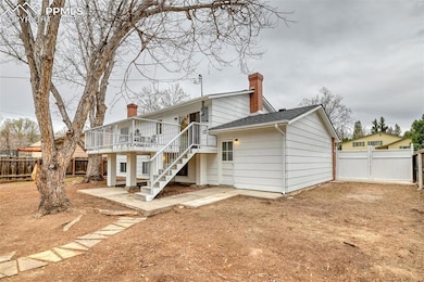 Rear view of property with stairs, a gate, a chimn