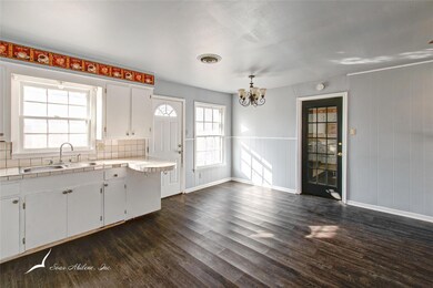 Kitchen also with dark hardwood, wood-style floors